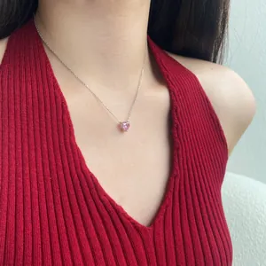 Vue détaillée du collier avec pendentif cœur en cristal rose porté par un mannequin