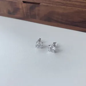 Detailopname van 8mm ronde zirkonia oorstoppers met een zilveren 4-klauw zetting