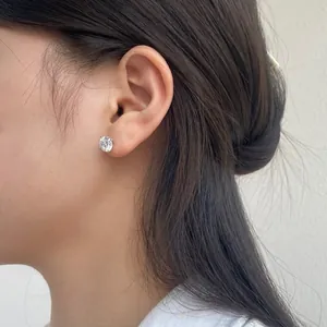 Detailopname van een S925 zilveren oorknopje met 8mm zirkonia op een modeloor