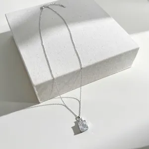 Detailed close-up of a silver necklace with a radiant ice-cut rectangular zircon pendant