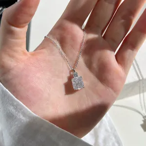Macro shot of S925 sterling silver necklace with ice-cut carbon diamond pendant on hand
