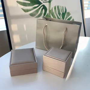 Elegantes champagnerfarbenes Schmuckschachtel-Set mit passender Tragetasche auf Tisch