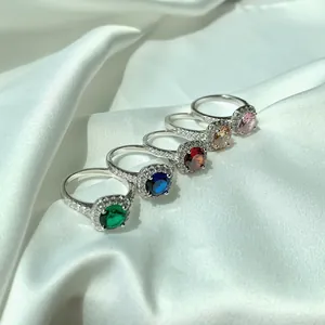Dettaglio degli anelli in argento S925 con zirconi colorati e design a cerchio halo
