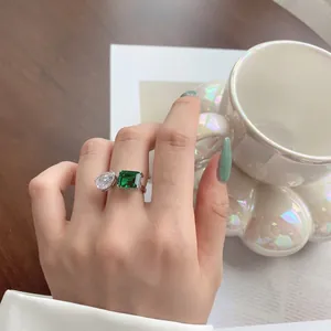 Close-up of S925 sterling silver ring with pear-cut and emerald-cut gemstones on finger