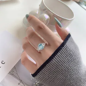 Detail van smaragd geslepen aquamarijn ring met zijstenen in een lifestyle setting