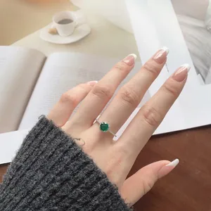 Detailed view of an S925 silver ring featuring a round green gem with halo diamond setting