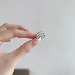 Detalle de anillo de plata de ley S925 con diseño en espiral de tres capas y circonitas