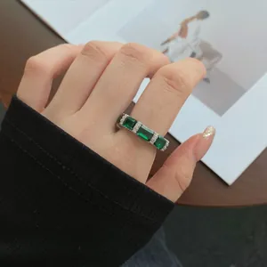 Close-up of S925 sterling silver ring with emerald cut green stones and pavé diamonds