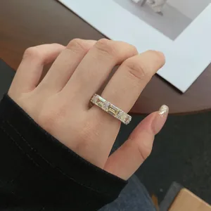 Detail shot of a silver band ring with rectangular yellow stones and small white diamonds