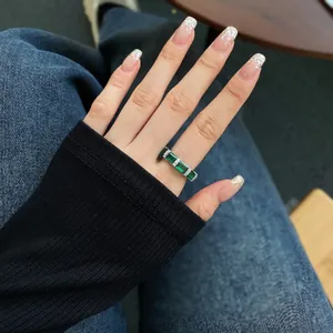 Close-up of S925 silver ring with emerald-cut green gems and paved diamonds