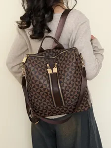 Women's backpack with geometric triangle pattern and gold zippers shown on a model