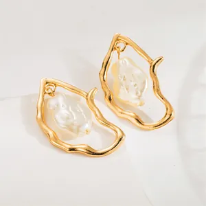 Baroque irregular gold earrings with white baroque pearl pendants in a minimalist setting