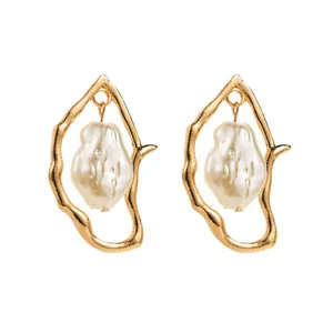Irregular golden earrings with baroque pearls in elegant minimalist French retro style
