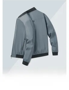 Detail view of the grey bomber jacket back showing a shield metal logo and ribbed hem
