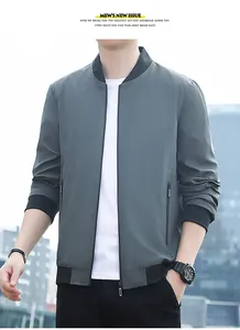 Close-up of a grey-blue bomber jacket with black ribbed collar and cuffs in urban setting