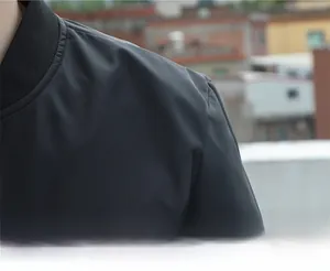 Close-up of the ribbed collar and structured shoulder design on a gray baseball jacket