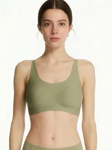 Front view of seamless olive green wire-free bra with wide straps on a model