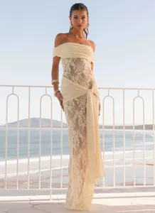 Detailed lace pattern on an off-white off-shoulder maxi dress for resort styling