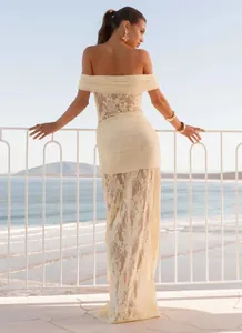 Rear view of beige lace hollow out bodycon dress with elegant ribbon details on a terrace
