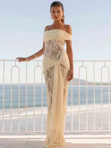 Champagne off-shoulder lace maxi dress with chic ribbon streamers on a seaside balcony