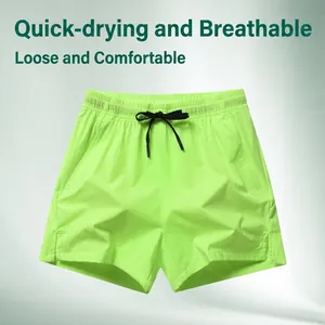 Detailed close-up of fluorescent green quick-dry sports shorts with black drawstring and elastic waist