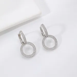 Sparkling zircon encrusted hoop earrings with silver geometric circles on a white background