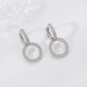 Sparkling silver drop earrings with white zircons on a minimalist white background