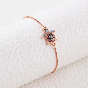 Macro detail of rose gold turtle bracelet featuring colorful pave-set zircon stones