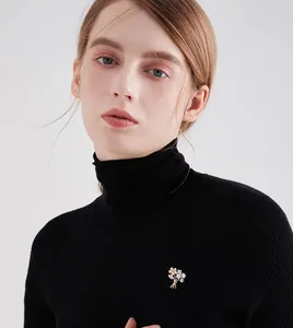 Exquisite gold flower bouquet brooch with sparkling crystals on a black knit sweater