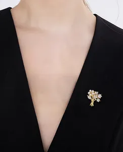 Detailed view of flower brooch with white pearls and zircons on black blazer