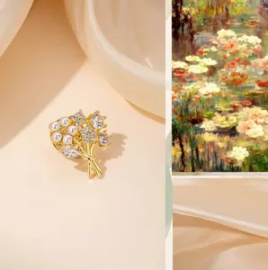 Detailed close-up of golden flower brooch with pearls and zircon on silk fabric