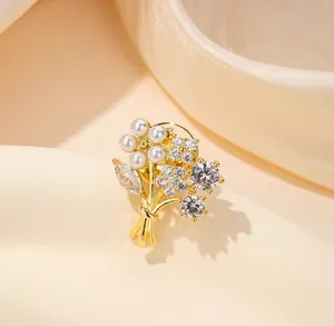 Detailed close-up of a floral brooch featuring white pearls and marquise-cut zircons