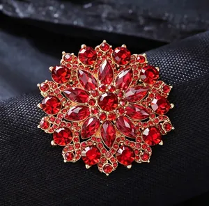Detailed macro of vintage crystal sunflower brooch with red rhinestones and gold base