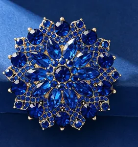 Close-up of deep blue sunflower crystal brooch with gold plated intricate petal details