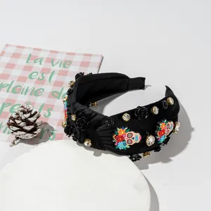 Detail of black velvet headband with skull ornaments and rhinestones for Halloween