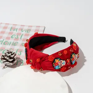 Halloween headband with red roses, skulls and rhinestones on a wide knotted velvet band
