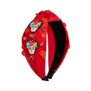 Detail of red velvet headband with skull, roses, and gemstone knots for Halloween