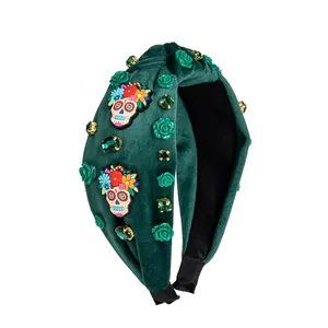 Detailed view of green velvet headband with candy skulls, resin roses and rhinestones