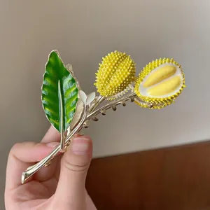 Detailed view of handmade 3D durian hair claw clip featuring golden alloy and enamel finish