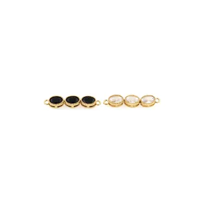 Macro detail of 18K gold plated connectors with black and clear oval cubic zirconia