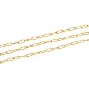 Macro detail of 18K gold-plated paperclip chain with polished and twisted oval link texture
