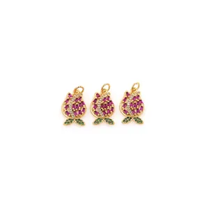 Dettaglio di tre ciondoli a fiore placcati oro 18K con pietre preziose rosso e verde