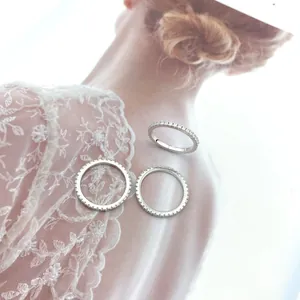 Three silver 925 eternity rings with sparkling zircon stones on artistic card