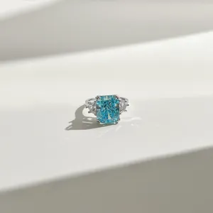 Macro shot of Radiant-cut sea blue gemstone ring with triangular side stones