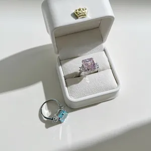 Detailed view of radiant-cut pink and blue diamond rings in a crown jewelry box