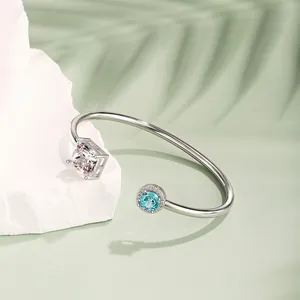 Detailaufnahme des S925 Silberarmreifs mit quadratischem und blauem Stein auf Stein