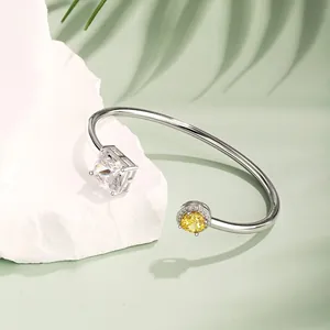 Makroaufnahme des Silberarmbands mit eckigem Zirkonia und gelbem Edelstein auf Stein
