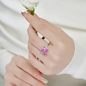 Gros plan d'une bague moissanite rose 6ct taille émeraude sur la main du mannequin