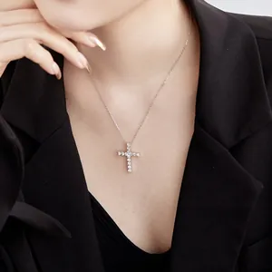 Gros plan du collier croix en argent sterling S925 avec zircons en forme de cœur sur modèle