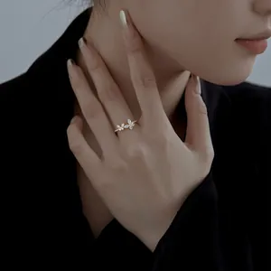 Close-up of golden butterfly ring featuring sparkling zircon wings on a model's finger